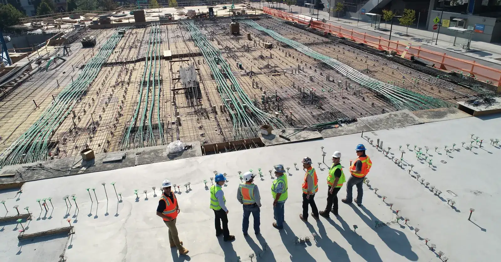 Aerial view of a site team standing on a large concrete slab beside laid reinforcement
