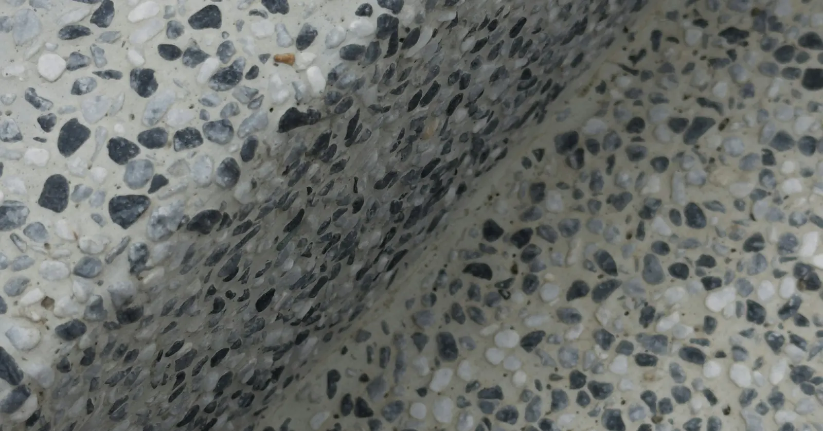 Close view of a grey terrazzo-style surface with dark and pale stone chips